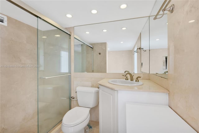 bathroom with vanity, an enclosed shower, tile walls, and toilet