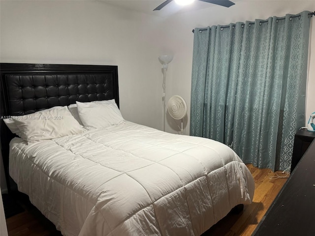 bedroom with dark hardwood / wood-style floors and ceiling fan