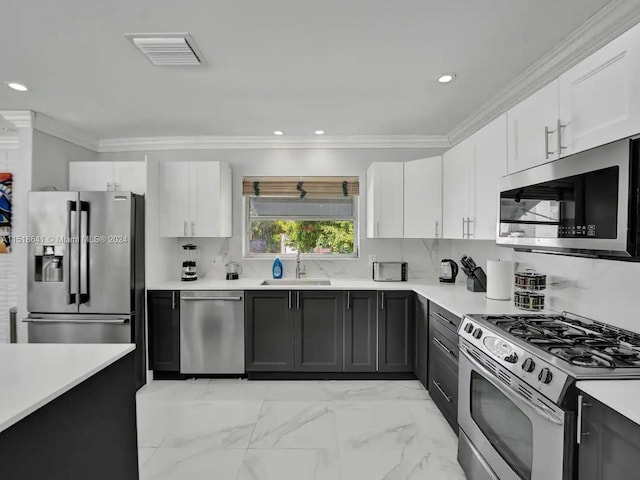 kitchen featuring sink, light tile floors, crown molding, stainless steel appliances, and white cabinetry