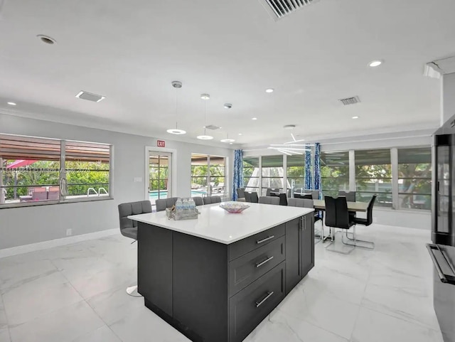 kitchen with light tile floors, a kitchen island, and pendant lighting