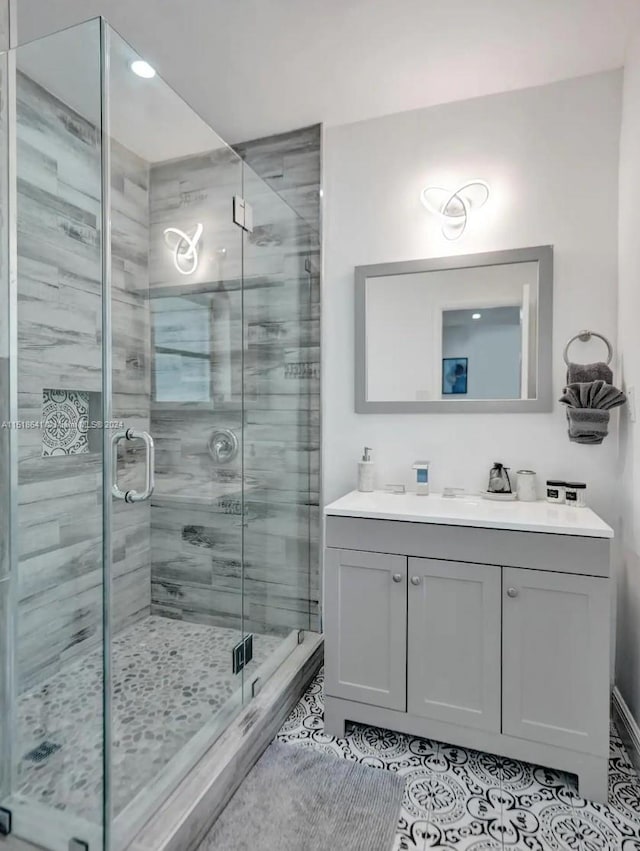 bathroom featuring tile flooring, an enclosed shower, and vanity