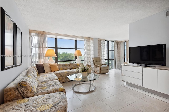 living room with expansive windows, a textured ceiling, and light tile flooring