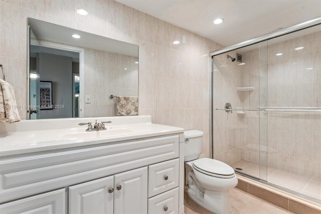 bathroom featuring tile walls, large vanity, an enclosed shower, tile floors, and toilet