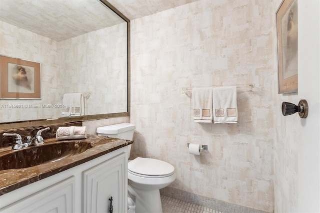 bathroom with vanity, toilet, and tile flooring