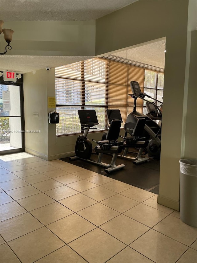 exercise room with tile floors and a textured ceiling