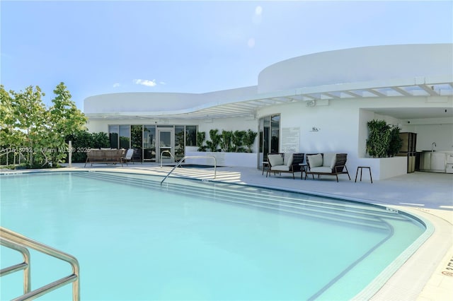 view of pool featuring an outdoor hangout area, sink, and a patio area