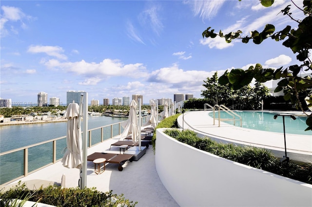 exterior space featuring a pool, a patio area, and a water view