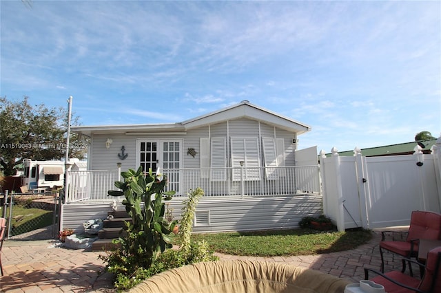 view of front of home featuring a patio area, a gate, and fence