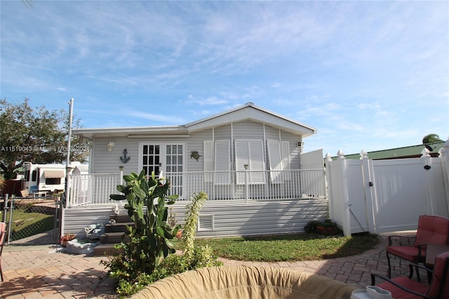 view of front of home featuring a patio area, a gate, and fence