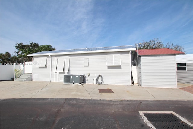 exterior space with a patio area, metal roof, central AC, and fence