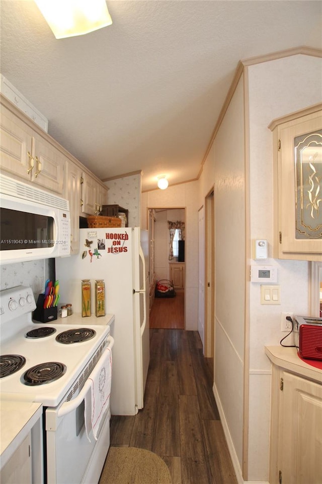 kitchen featuring dark wood-style floors, crown molding, light countertops, cream cabinets, and white appliances