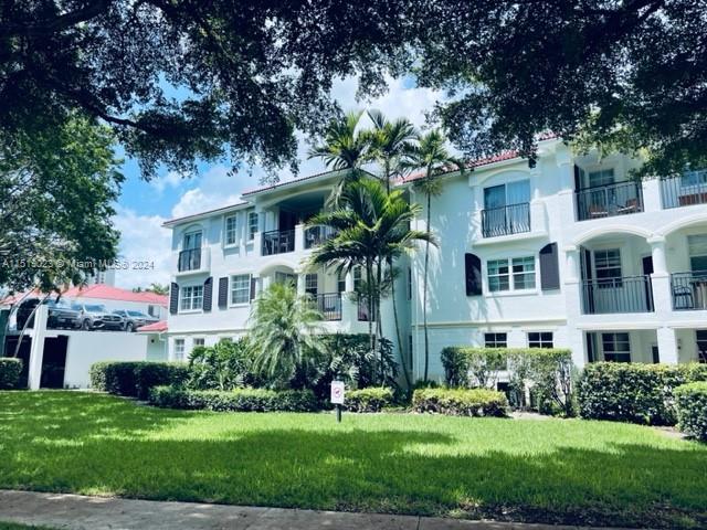 view of front of property featuring a front lawn and a balcony