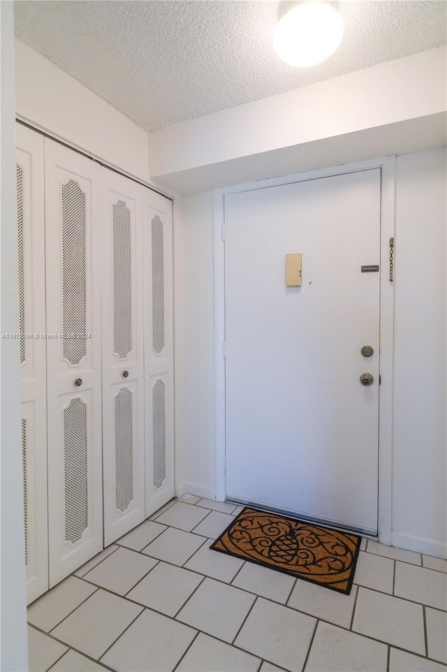 tiled foyer entrance featuring a textured ceiling