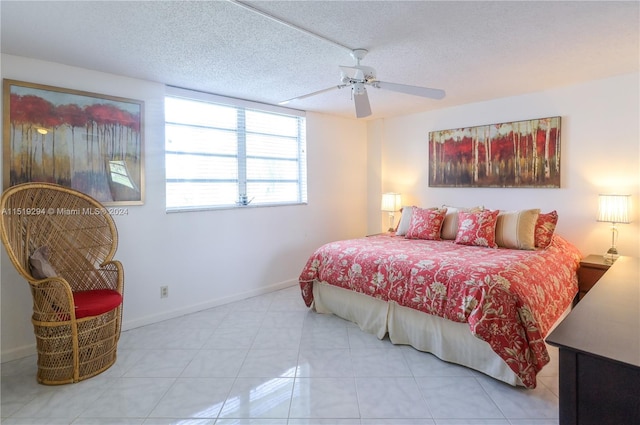 bedroom with ceiling fan, a textured ceiling, and light tile patterned flooring