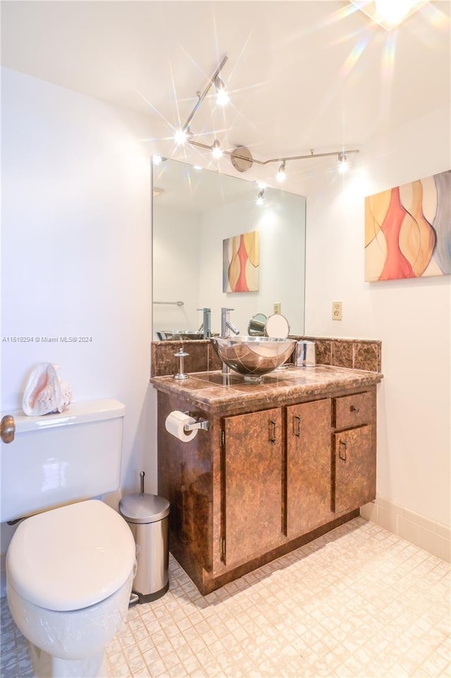 bathroom featuring tile patterned flooring, toilet, and vanity