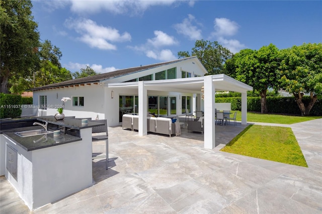 view of patio / terrace with outdoor lounge area, an outdoor kitchen, and sink