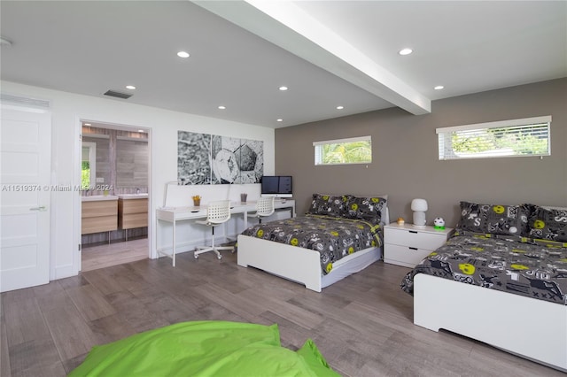 bedroom with hardwood / wood-style floors and beam ceiling