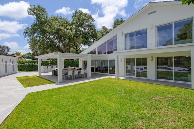 back of house with a lawn and a patio