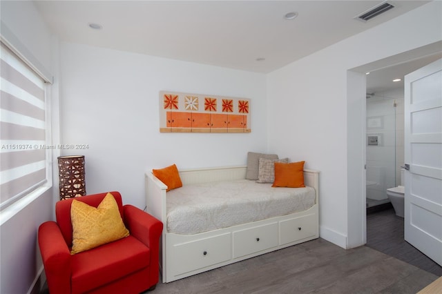 bedroom with dark hardwood / wood-style floors and connected bathroom