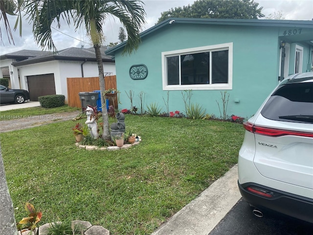 view of side of home with a lawn and a garage