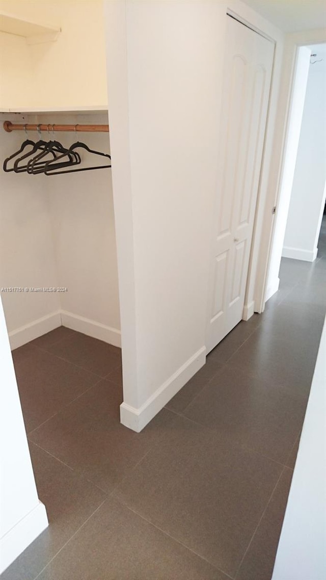 corridor featuring dark tile flooring