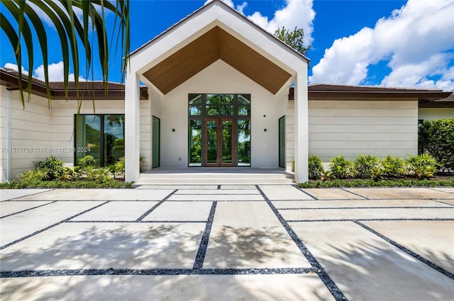 property entrance with stucco siding and french doors