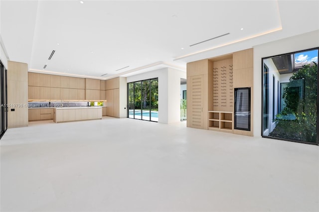 unfurnished living room featuring finished concrete flooring