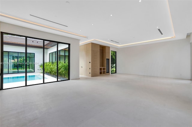 empty room with concrete floors and a tray ceiling