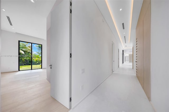 corridor featuring light wood finished floors and recessed lighting