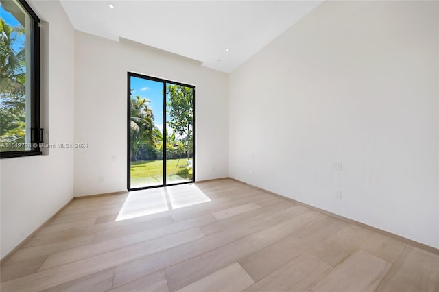 spare room featuring vaulted ceiling, light wood-style flooring, and recessed lighting