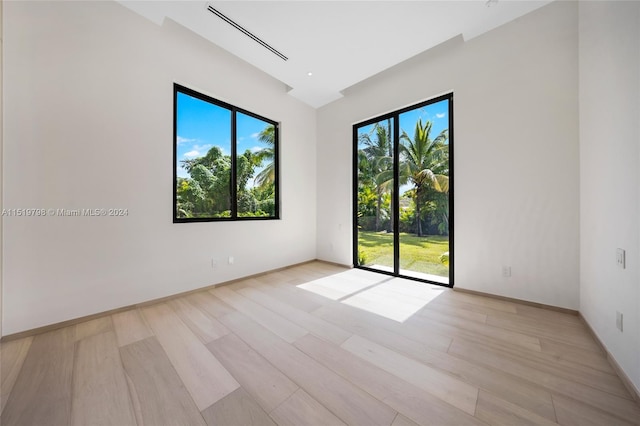 unfurnished room featuring baseboards and light wood-style floors