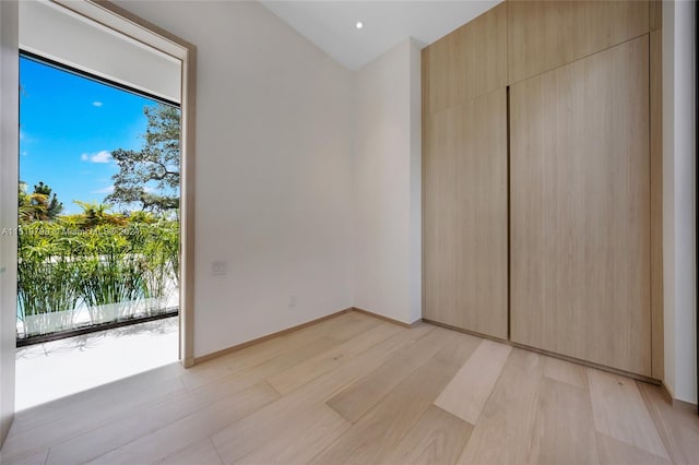 unfurnished bedroom with a closet, baseboards, and light wood-style floors