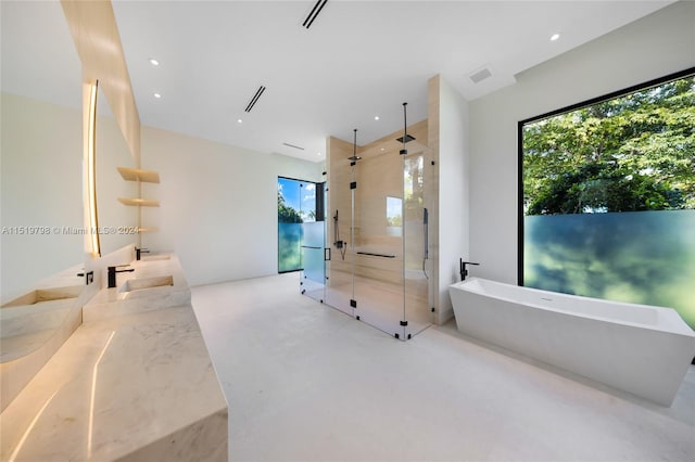 full bath featuring a freestanding tub, plenty of natural light, concrete flooring, and a stall shower