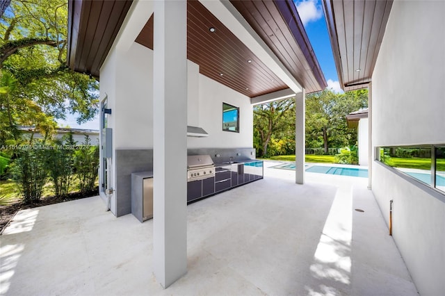 view of patio / terrace with a grill, an outdoor pool, and an outdoor kitchen