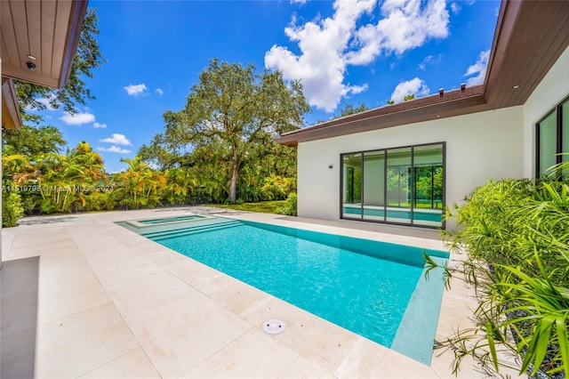 pool with an in ground hot tub and a patio