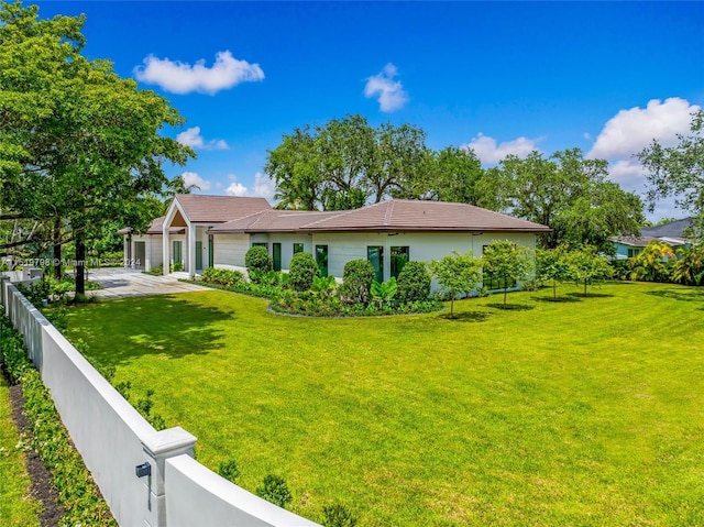 exterior space with a yard, an attached garage, and fence