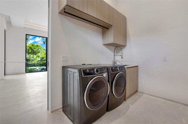 laundry room featuring washer and clothes dryer, cabinet space, baseboards, and a sink