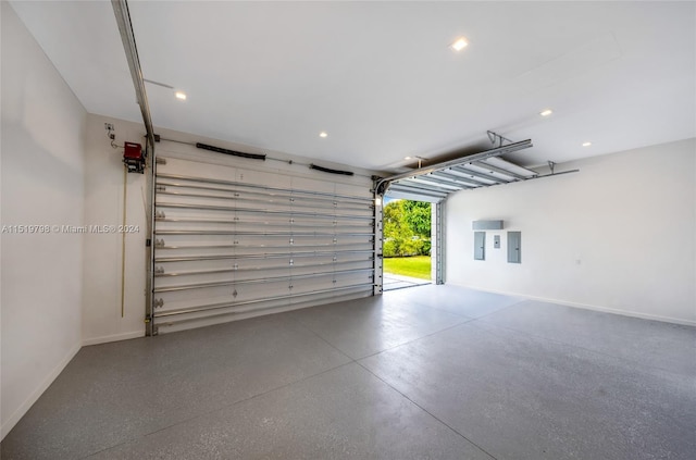 garage featuring electric panel, recessed lighting, and baseboards