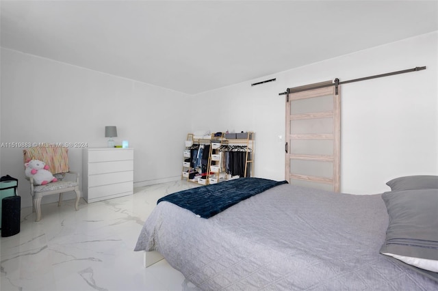 bedroom with a barn door and light tile flooring