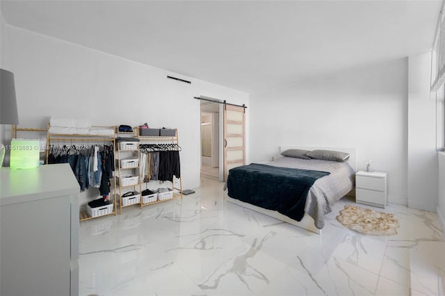 bedroom with light tile floors, a closet, and a barn door