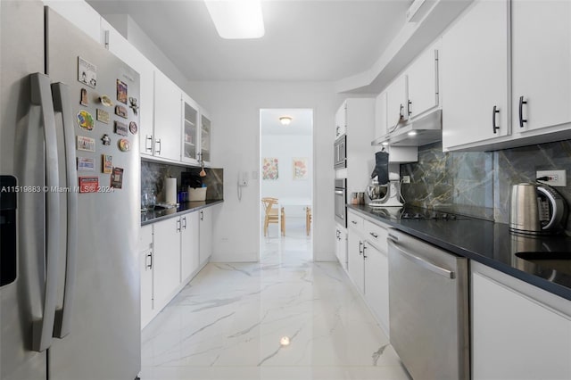 kitchen with appliances with stainless steel finishes, white cabinetry, backsplash, and light tile flooring