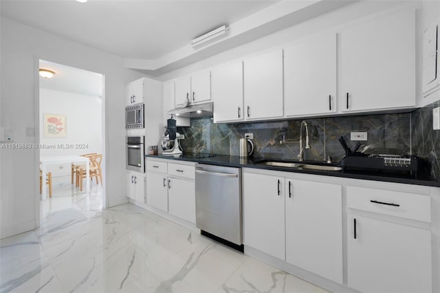 kitchen with light tile flooring, tasteful backsplash, appliances with stainless steel finishes, white cabinets, and sink