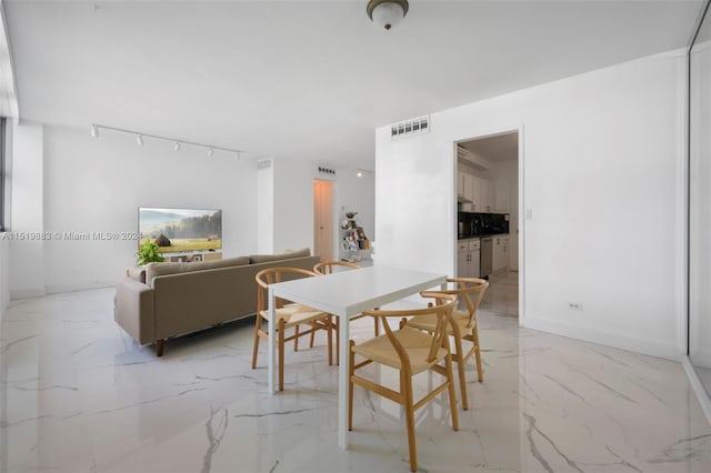 tiled dining area featuring track lighting