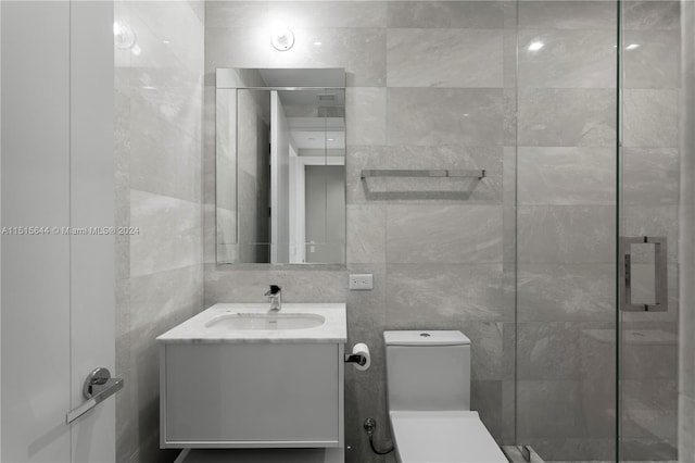 bathroom featuring tile walls, walk in shower, vanity, and toilet