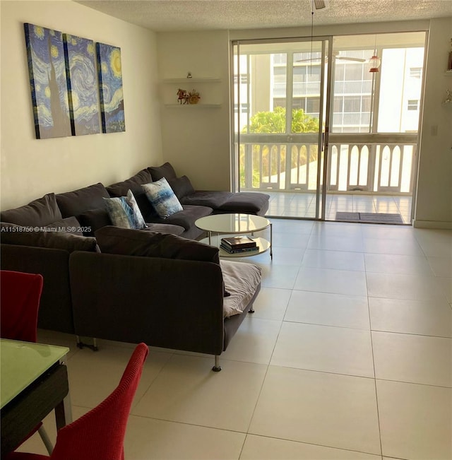 living area with a textured ceiling, a wall of windows, and tile patterned floors