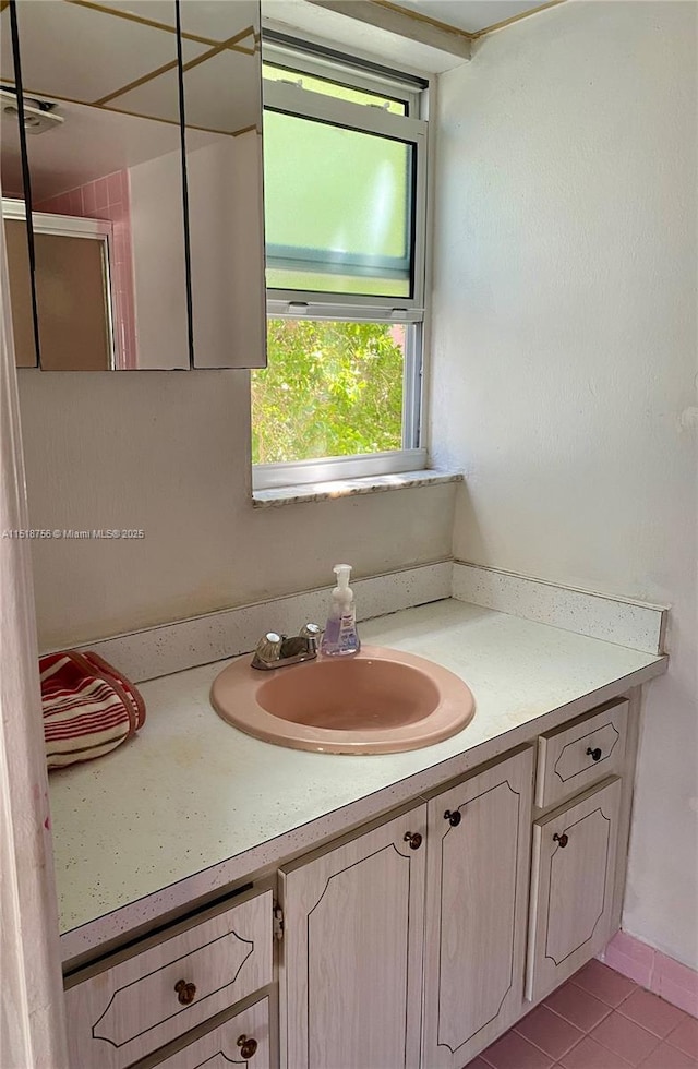 bathroom featuring a shower with door, tile patterned floors, and vanity