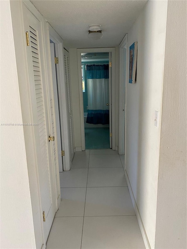 hall with tile patterned flooring and baseboards