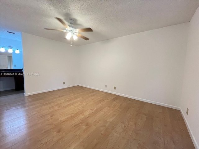 unfurnished room featuring a textured ceiling, ceiling fan, and light hardwood / wood-style flooring