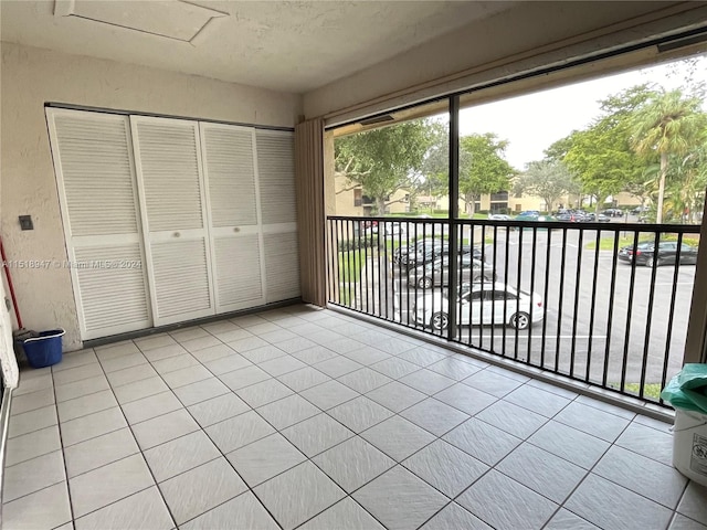 unfurnished bedroom featuring light tile flooring, a closet, and multiple windows