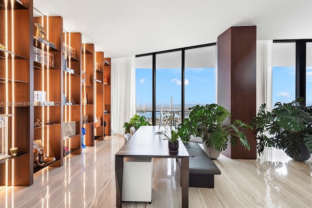 dining area featuring a water view and a wall of windows